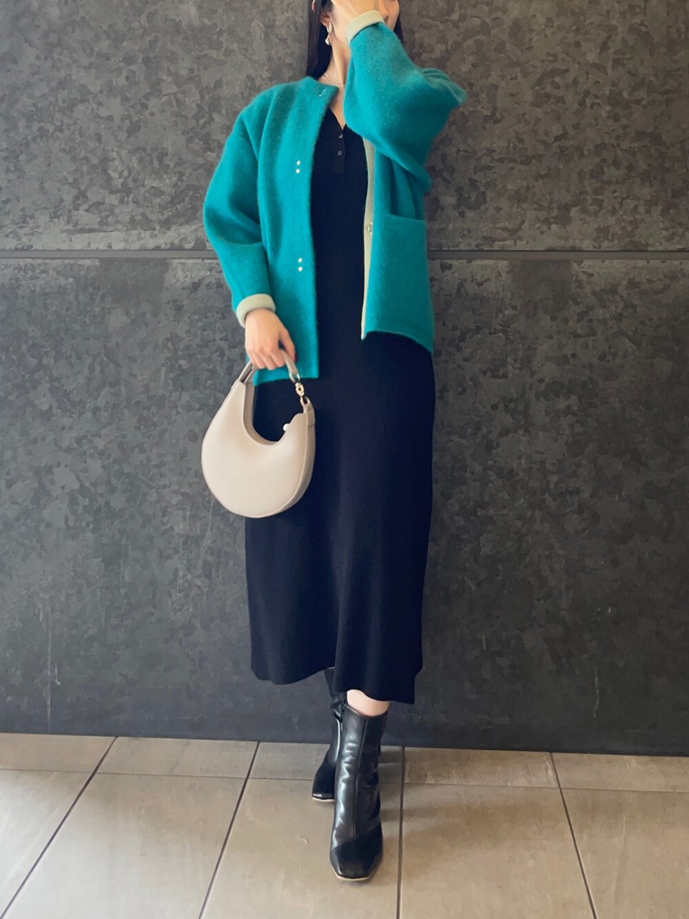 ホワイト系のハンドバッグ、ブラック系のブーツ、ブラック系のワンピースを着用したレディースの秋コーディネートの5枚目の写真