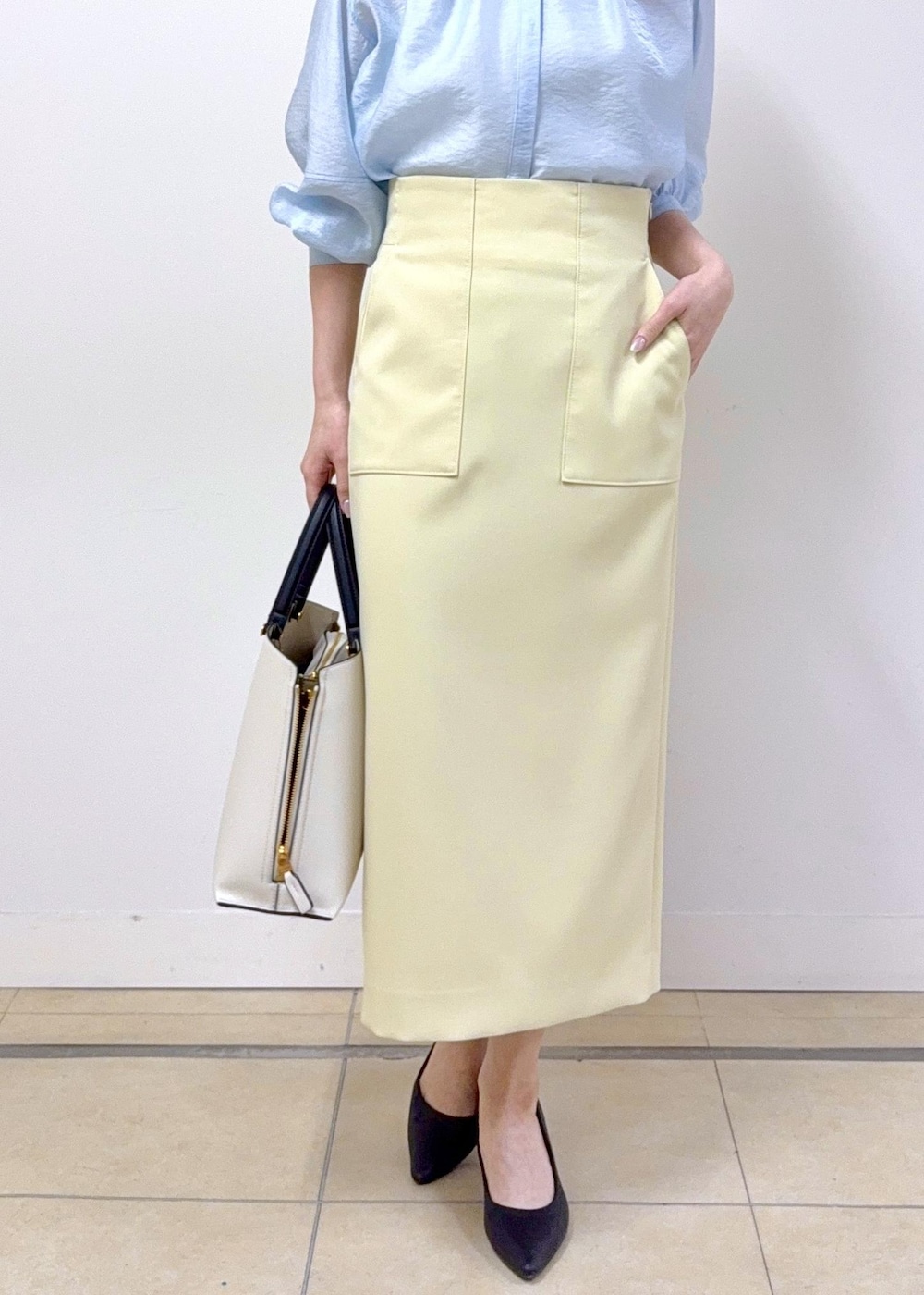 ベージュ系のスカート、ブルー系のシャツ/ブラウス、ホワイト系のトートバッグを着用したレディースの冬コーディネートの4枚目の写真