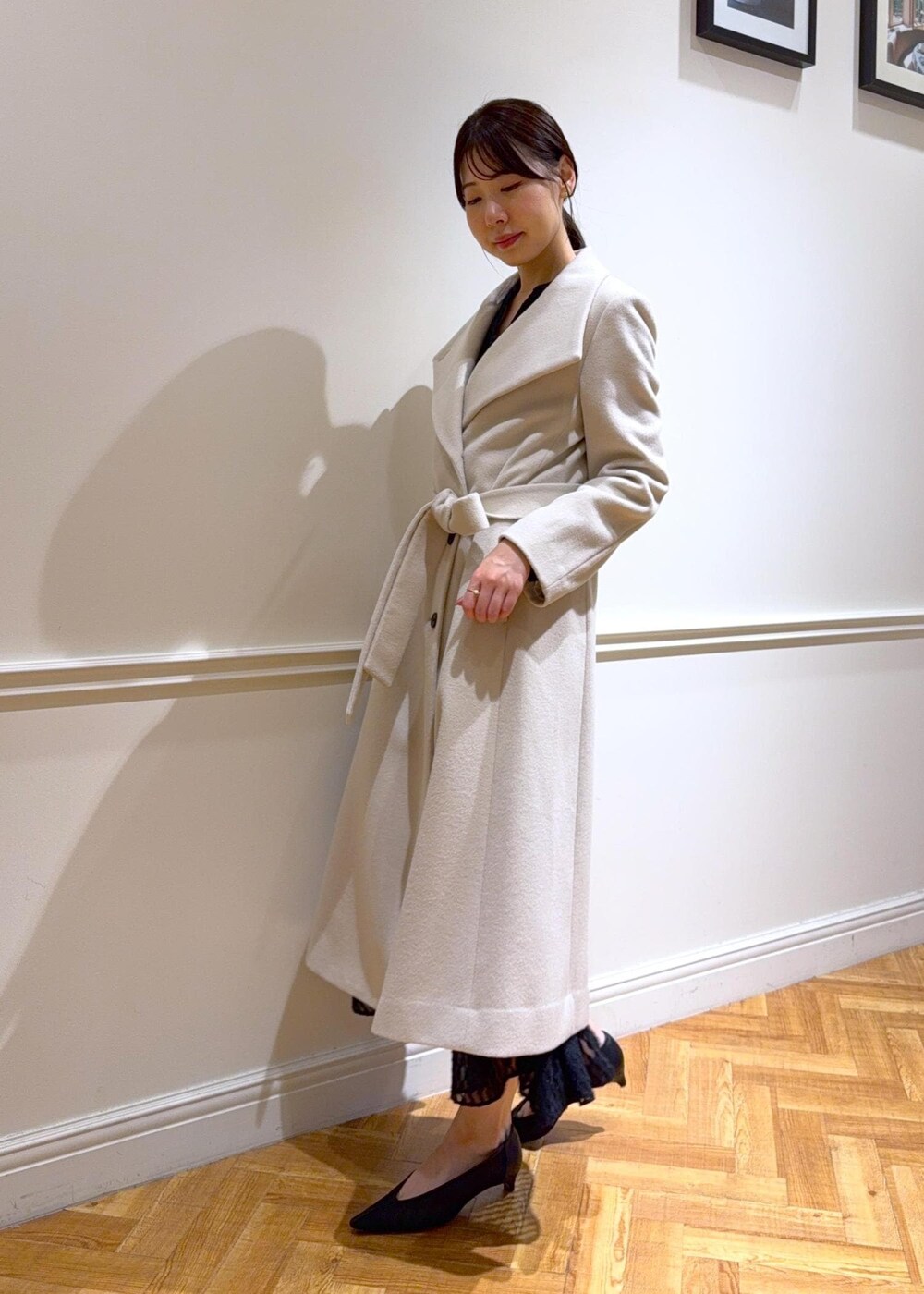 ブラック系のパンプス、パープル系のハンドバッグ、ホワイト系のステンカラーコートを着用したレディースの秋コーディネートの3枚目の写真