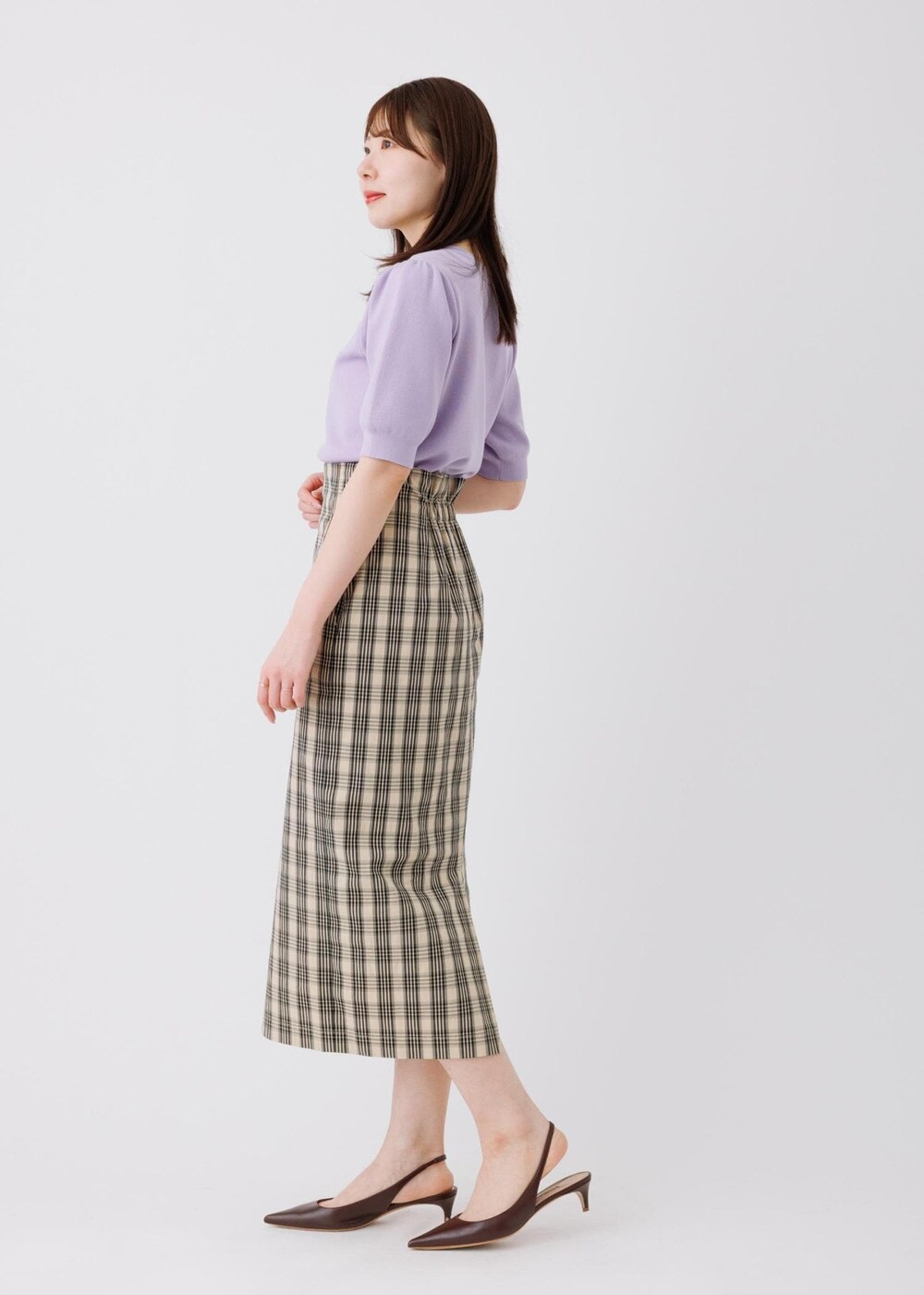 パープル系のニット/セーター、ベージュ系のスカートを着用したレディースの春コーディネートの3枚目の写真