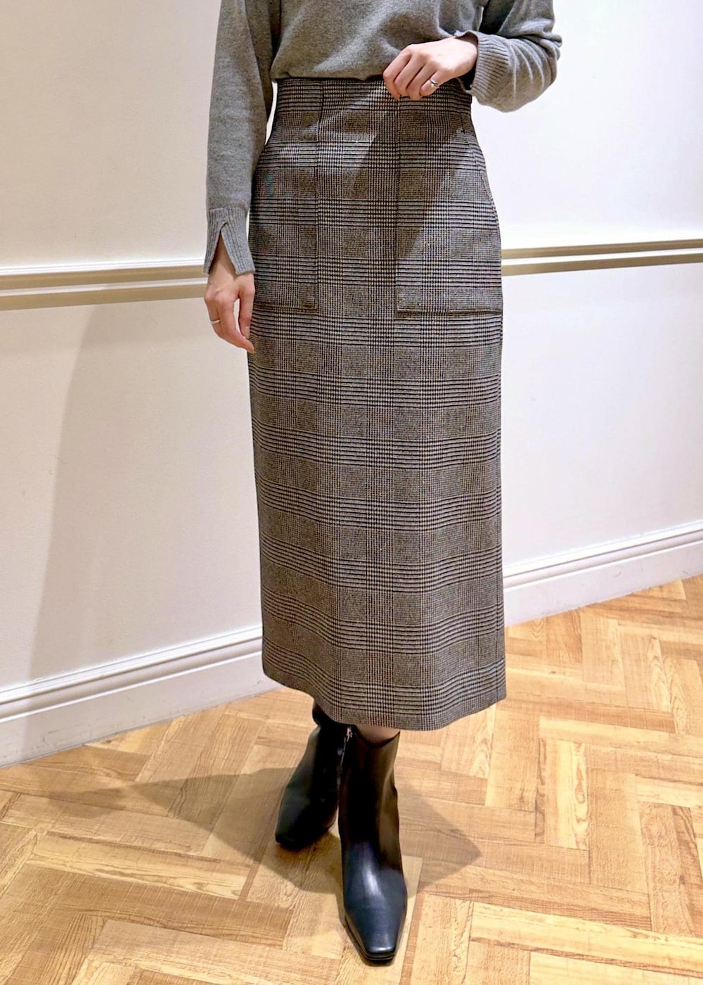 ブラック系のブーツ、グレー系のトートバッグ、ブラック系のステンカラーコートを着用したレディースの秋コーディネートの7枚目の写真