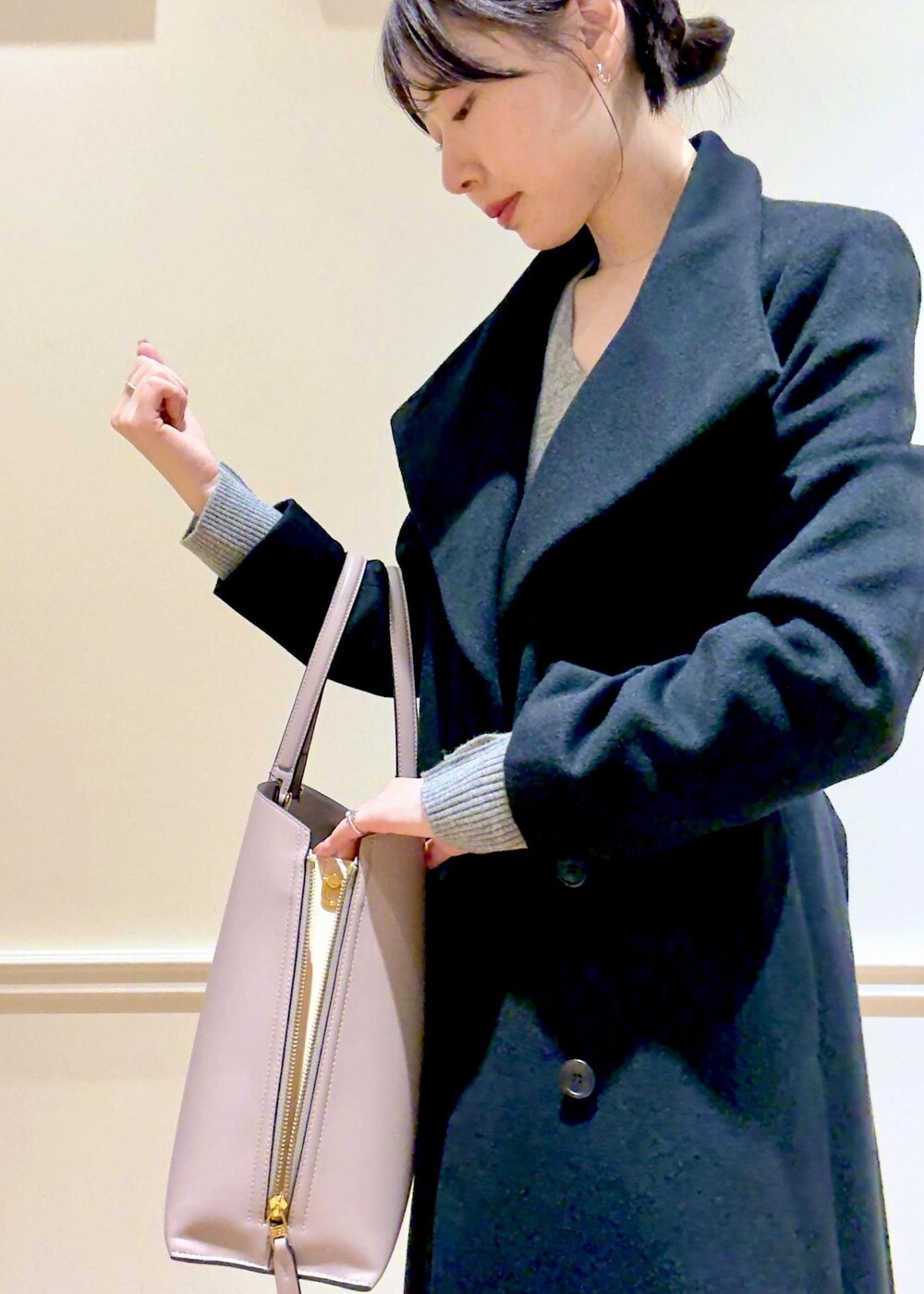 ブラック系のブーツ、グレー系のトートバッグ、ブラック系のステンカラーコートを着用したレディースの秋コーディネートの9枚目の写真