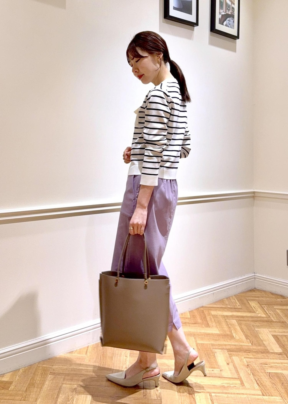 パープル系のスカート、ブラウン系のトートバッグ、ホワイト系のカーディガン/ボレロを着用したレディースの春コーディネートの3枚目の写真