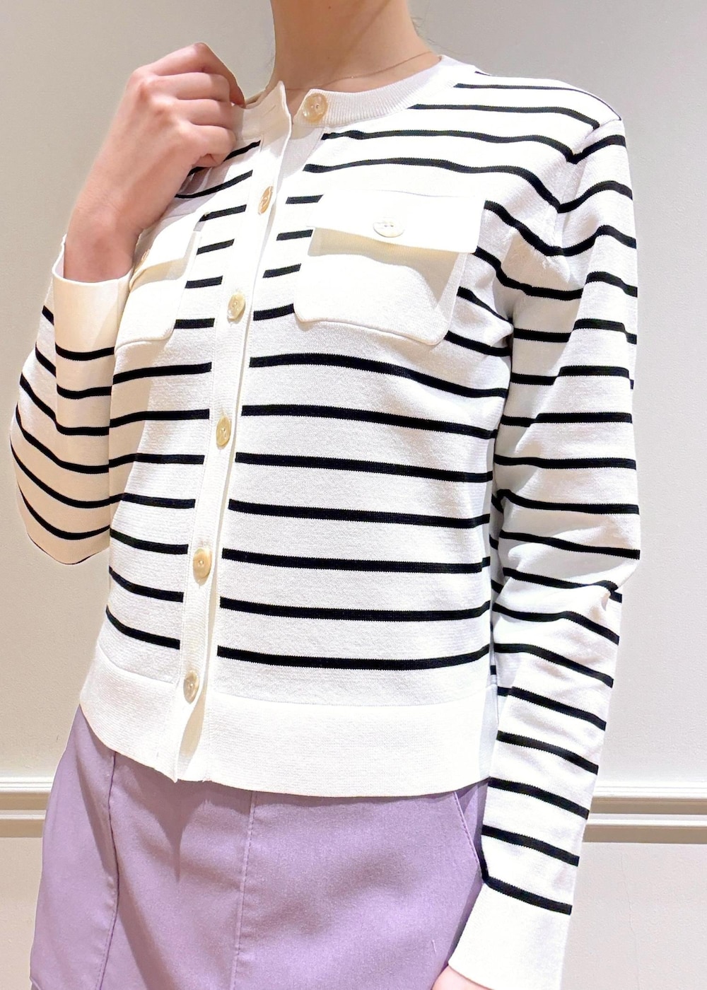 パープル系のスカート、ブラウン系のトートバッグ、ホワイト系のカーディガン/ボレロを着用したレディースの春コーディネートの6枚目の写真