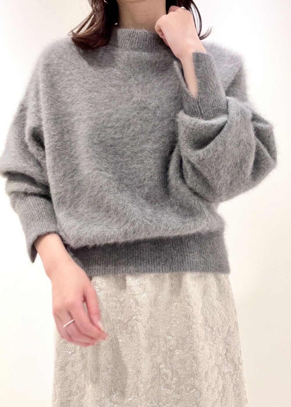 レッド系のショルダーバッグ、ブラック系のブーツ、グレー系のニット/セーターを着用したレディースの冬コーディネートの6枚目の写真