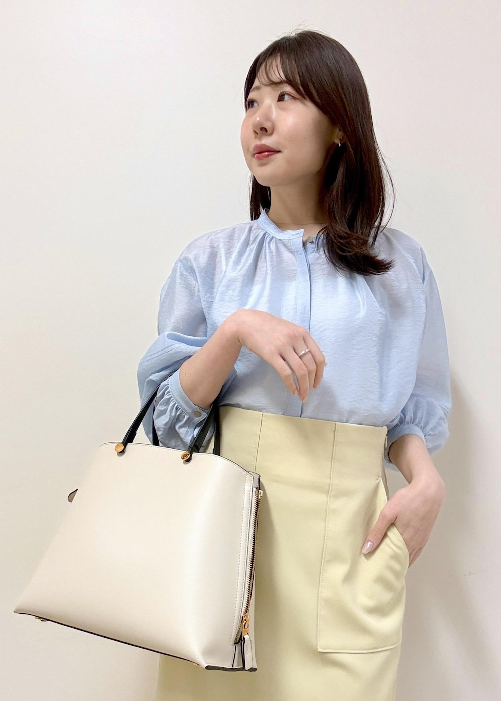 ベージュ系のスカート、ブルー系のシャツ/ブラウス、ホワイト系のトートバッグを着用したレディースの冬コーディネートの9枚目の写真