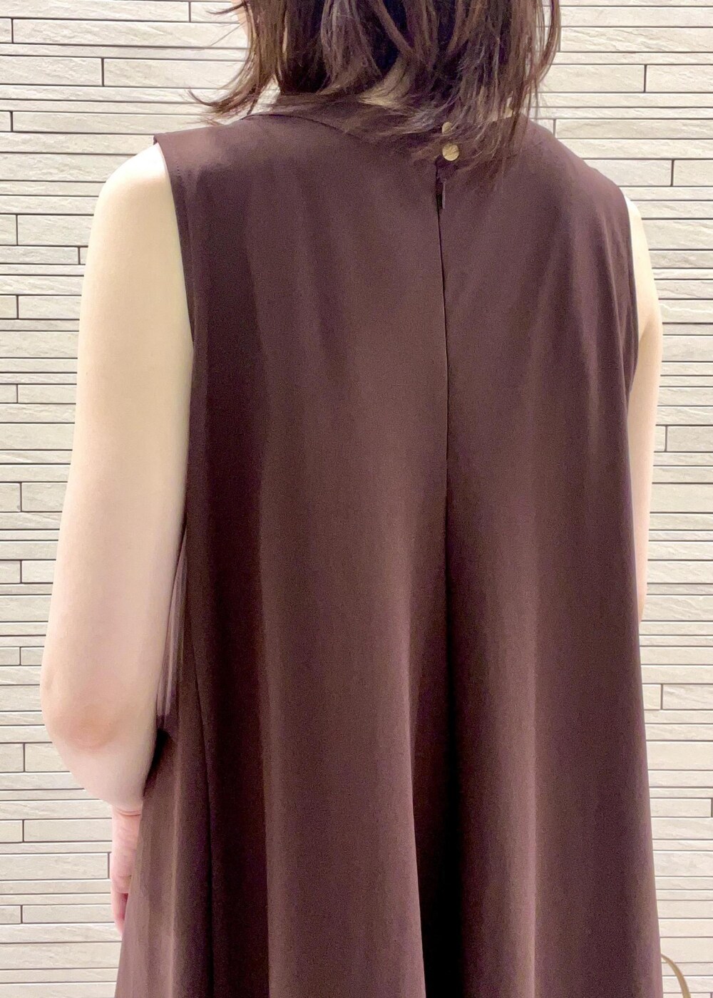 イエロー系のショルダーバッグ、ブラック系のサンダル、ブラウン系のワンピースを着用したレディースの夏コーディネートの6枚目の写真