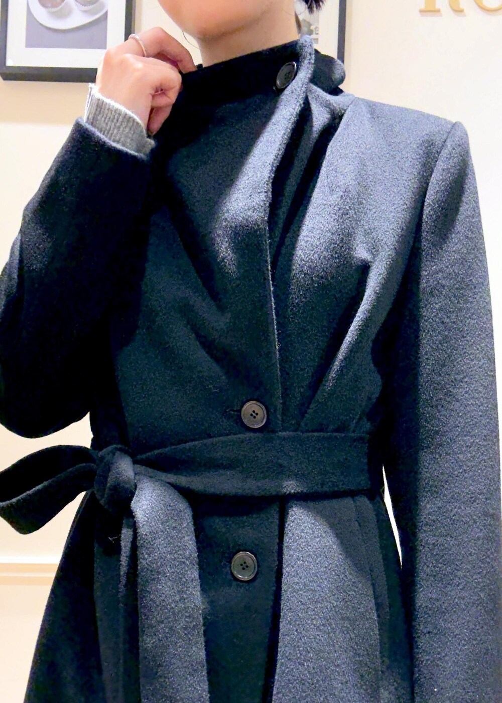 ブラック系のブーツ、グレー系のトートバッグ、ブラック系のステンカラーコートを着用したレディースの秋コーディネートの6枚目の写真