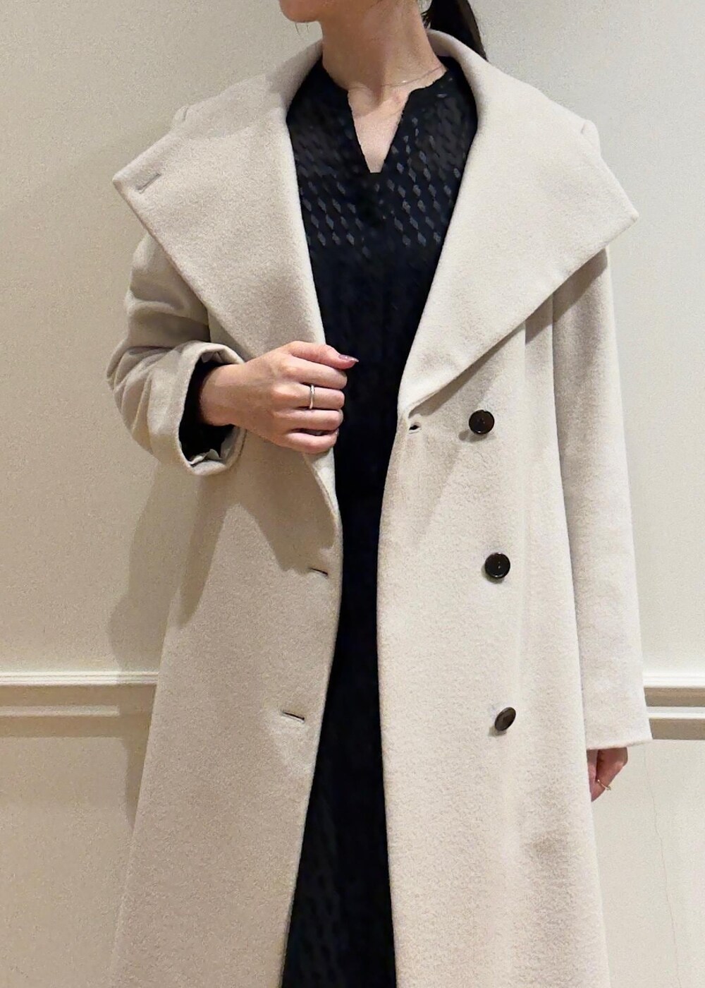 ブラック系のパンプス、パープル系のハンドバッグ、ホワイト系のステンカラーコートを着用したレディースの秋コーディネートの5枚目の写真