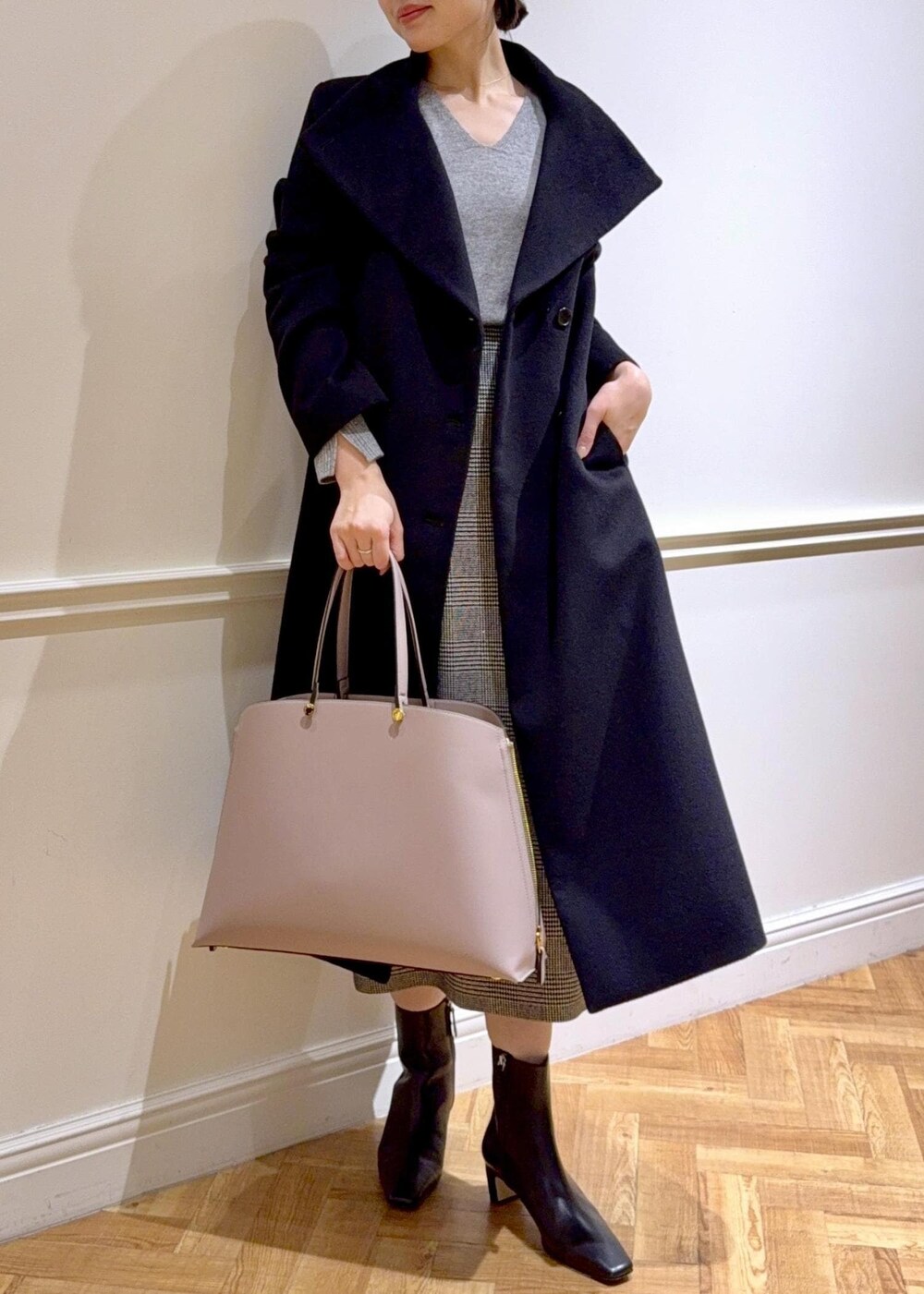 ブラック系のブーツ、グレー系のトートバッグ、ブラック系のステンカラーコートを着用したレディースの秋コーディネートの4枚目の写真
