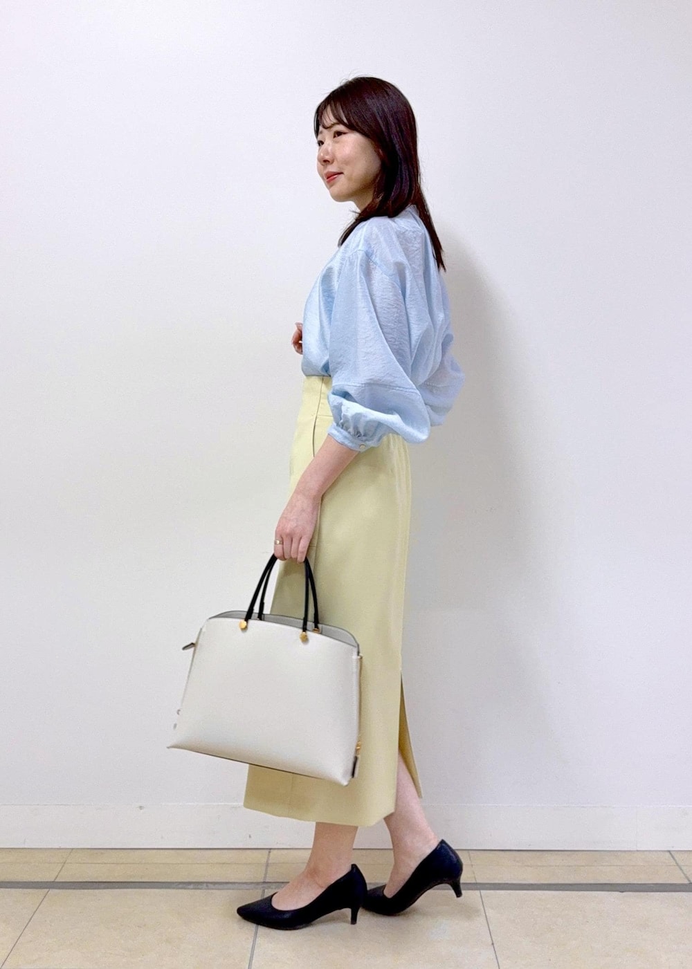 ベージュ系のスカート、ブルー系のシャツ/ブラウス、ホワイト系のトートバッグを着用したレディースの冬コーディネートの3枚目の写真