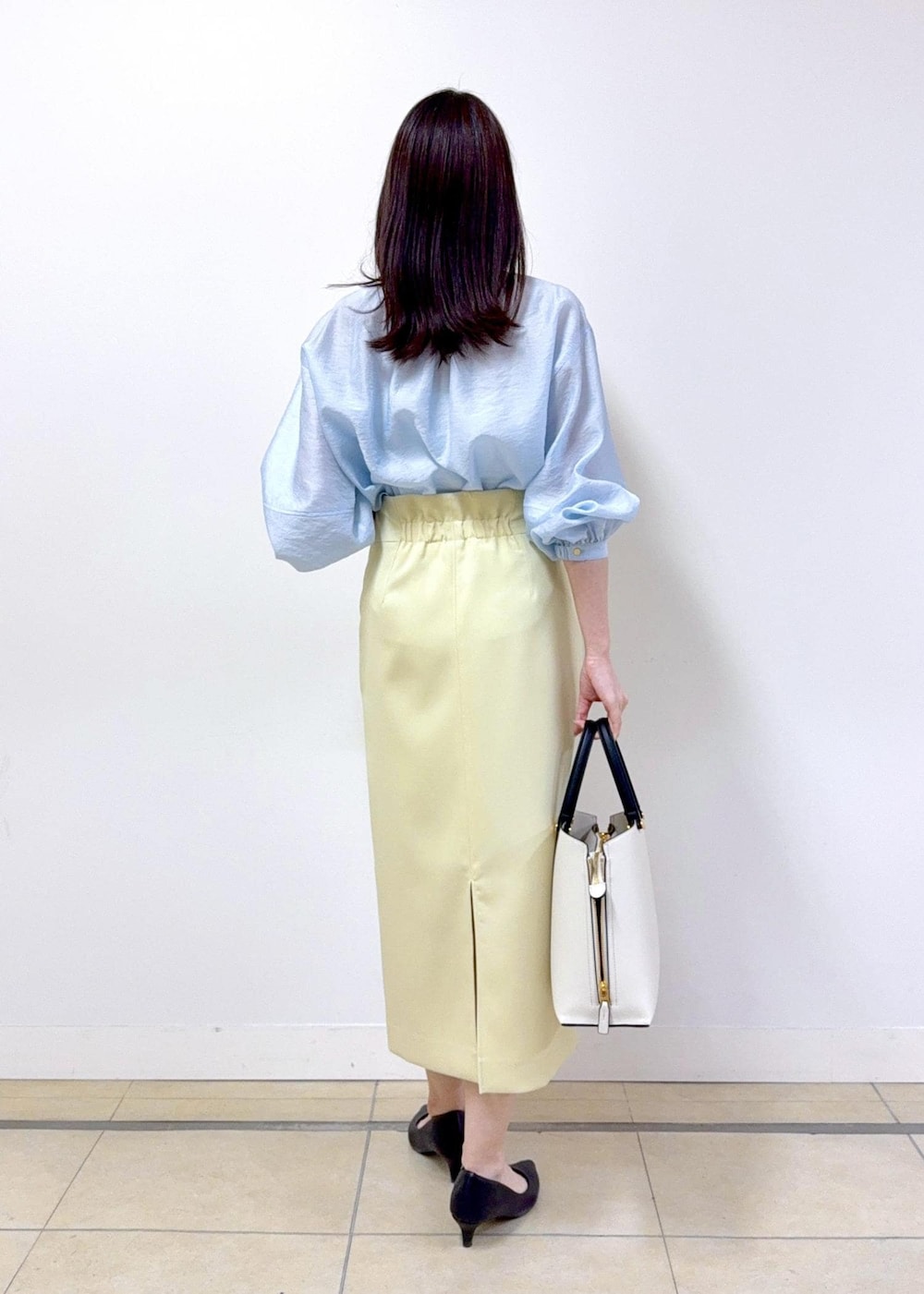 ベージュ系のスカート、ブルー系のシャツ/ブラウス、ホワイト系のトートバッグを着用したレディースの冬コーディネートの2枚目の写真