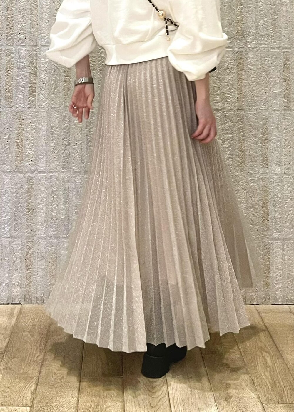 ブラック系のブーツ、シルバー系のスカート、ホワイト系のスウェットを着用したレディースの冬コーディネートの4枚目の写真