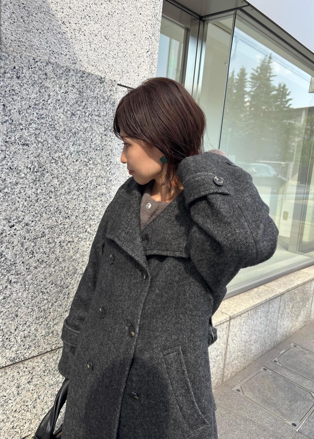 ブルー系のデニムパンツ、ブラック系のブーツ、ブラック系のハンドバッグを着用したレディースの秋コーディネートの7枚目の写真