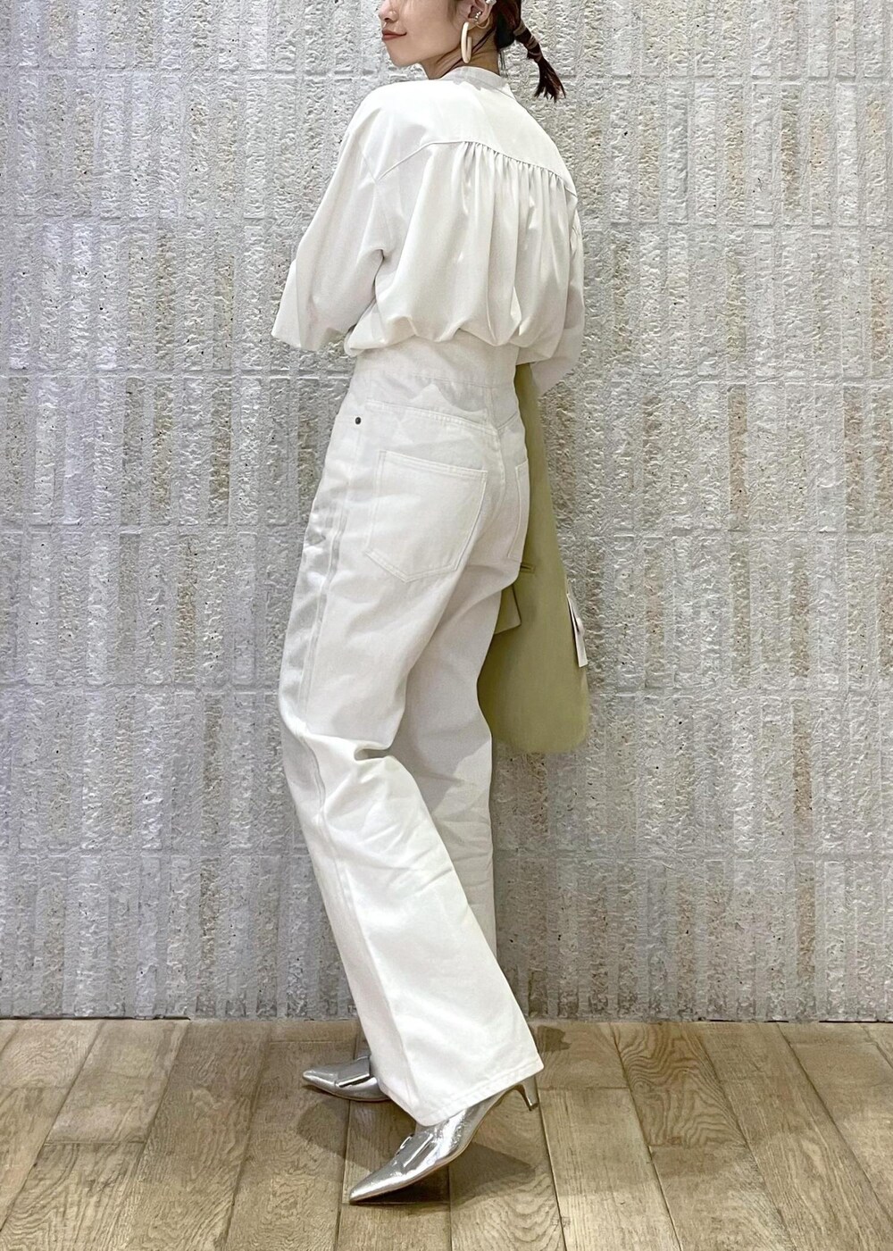 シルバー系のショルダーバッグ、シルバー系のパンプス、ホワイト系のシャツ/ブラウスを着用したレディースの冬コーディネートの3枚目の写真