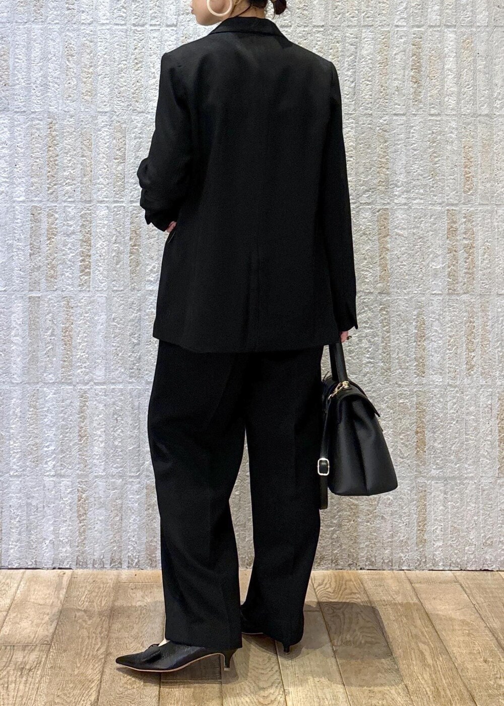 ブラック系のパンプス、ブラック系のキャミソール、ブラック系のハンドバッグを着用したレディースの冬コーディネートの8枚目の写真