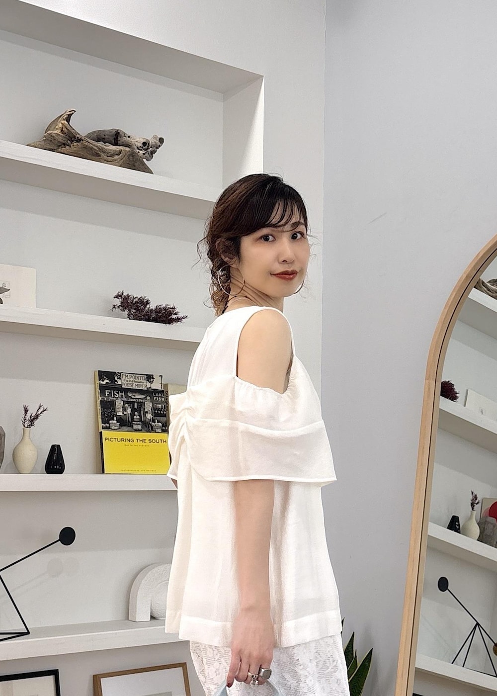 ホワイト系のキャミソール、ホワイト系のパンプス、ブルー系のショルダーバッグを着用したレディースの春コーディネートの8枚目の写真