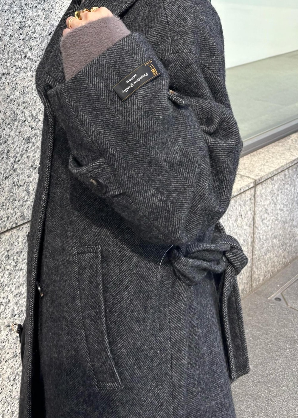 ブルー系のデニムパンツ、ブラック系のブーツ、ブラック系のハンドバッグを着用したレディースの秋コーディネートの3枚目の写真