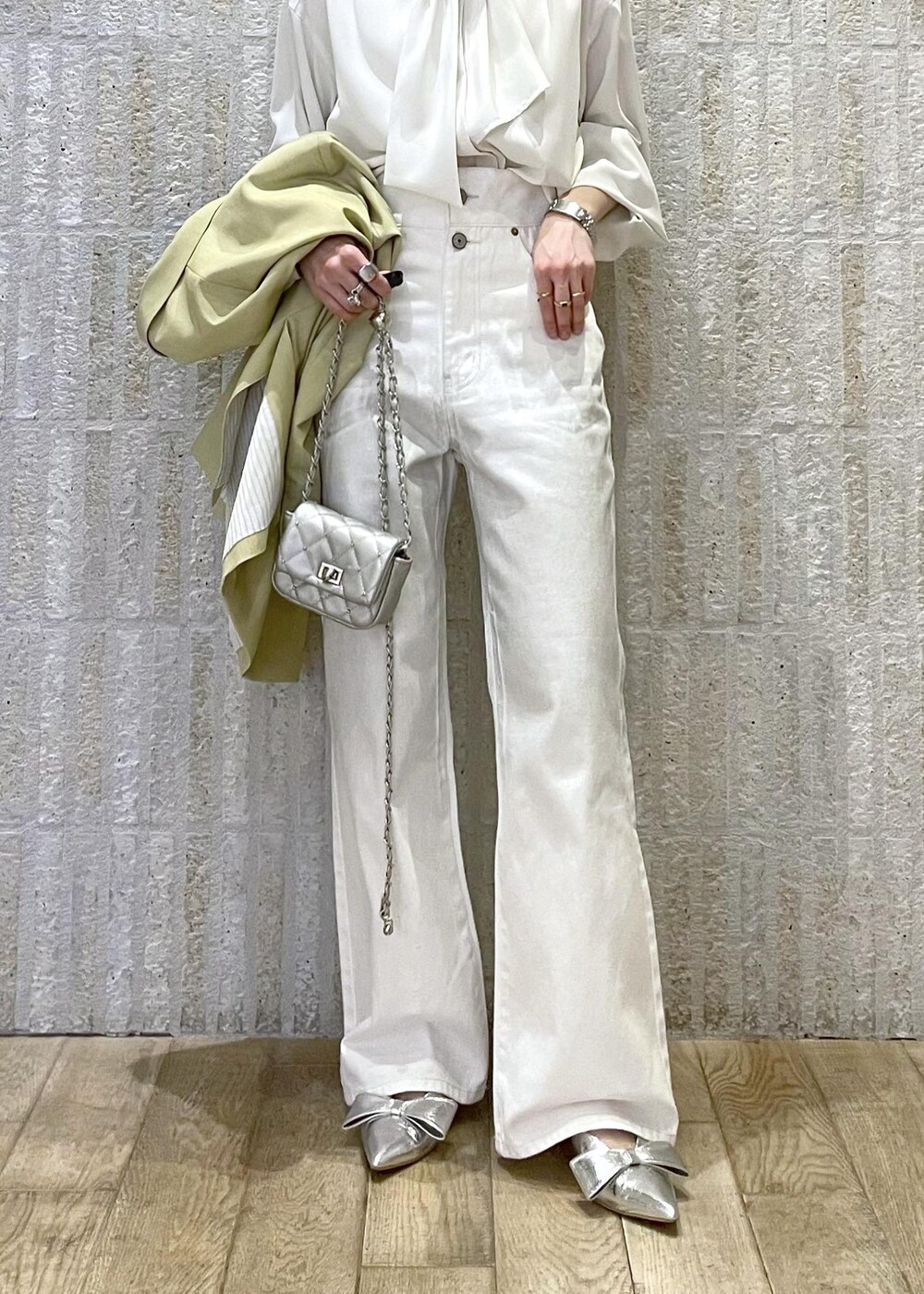 シルバー系のショルダーバッグ、シルバー系のパンプス、ホワイト系のシャツ/ブラウスを着用したレディースの冬コーディネートの2枚目の写真