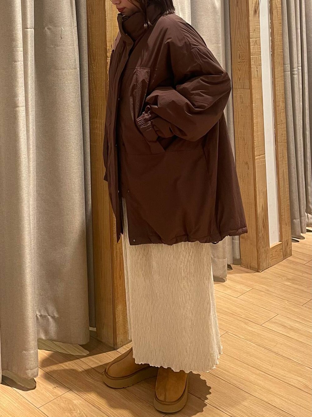 ブラウン系のブルゾン、ホワイト系のスカート、ブラウン系のその他シューズを着用したレディースの秋コーディネートの3枚目の写真