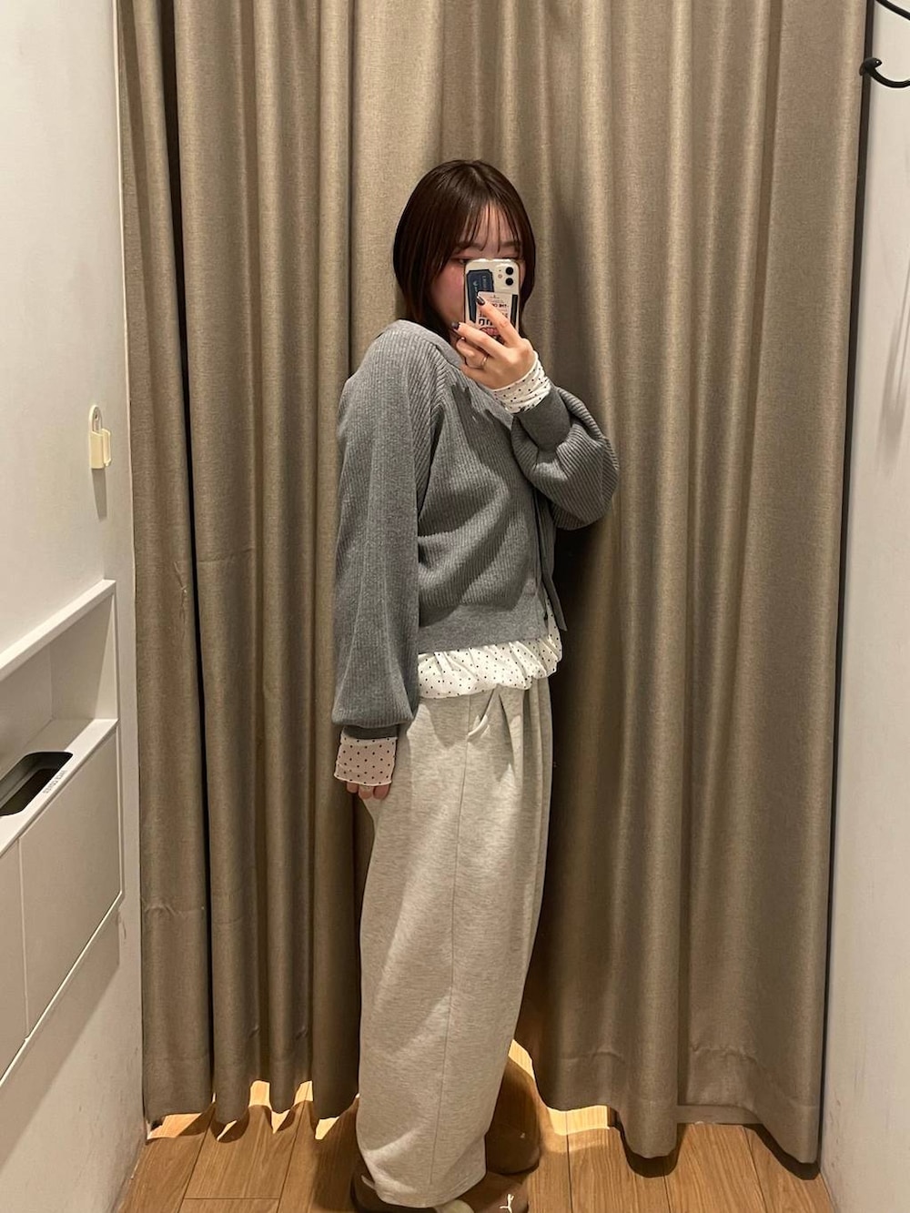 グレー系のスウェットパンツ、グレー系のカーディガン/ボレロ、ホワイト系のTシャツ/カットソーを着用したレディースの冬コーディネートの2枚目の写真