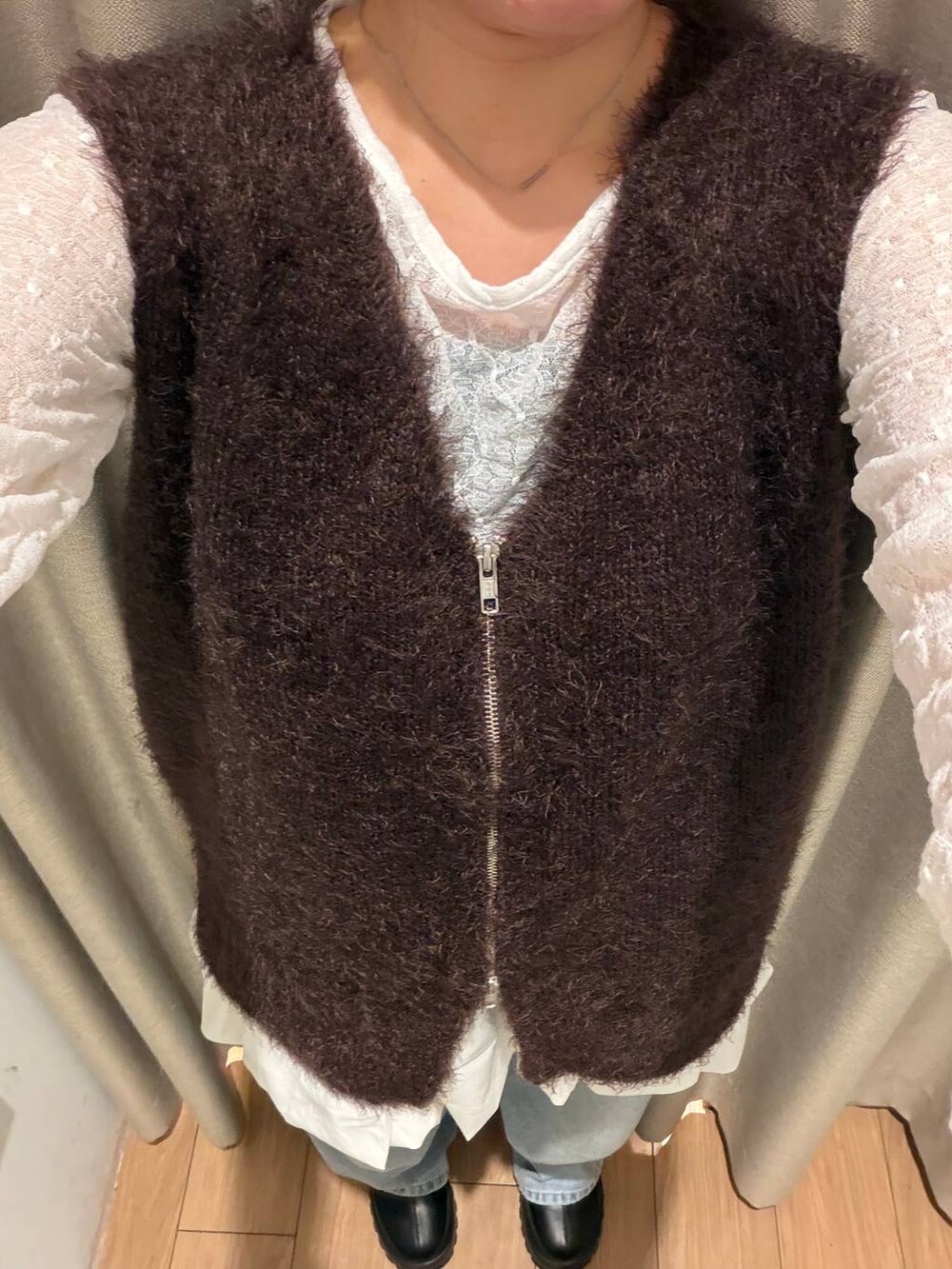 ブラック系のブーツ、ホワイト系のTシャツ/カットソー、ブラウン系のベストを着用したレディースの秋コーディネートの4枚目の写真