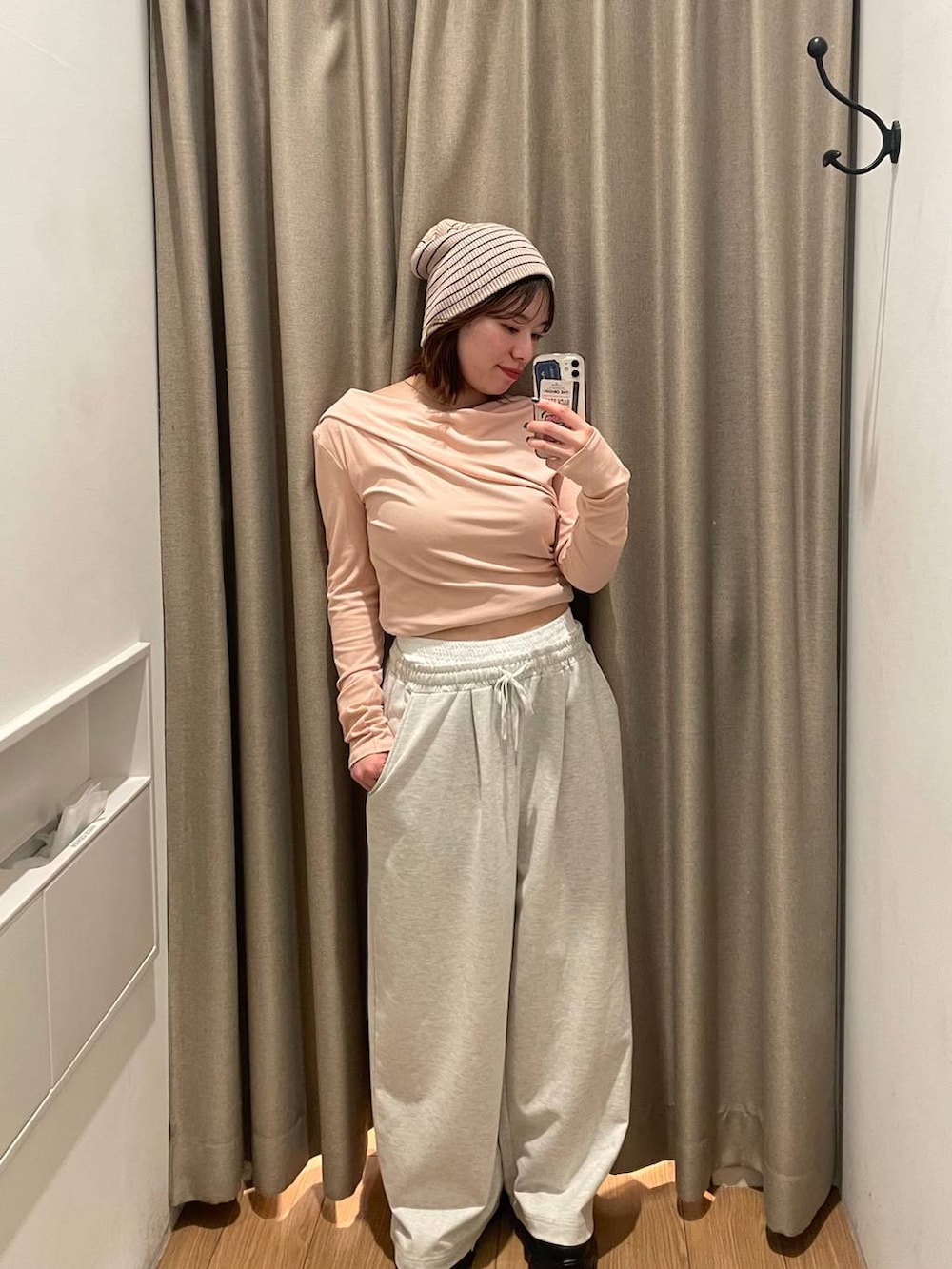 ピンク系のTシャツ/カットソー、グレー系のスウェットパンツ、ホワイト系のニットキャップ/ビーニーを着用したレディースの冬コーディネートの2枚目の写真