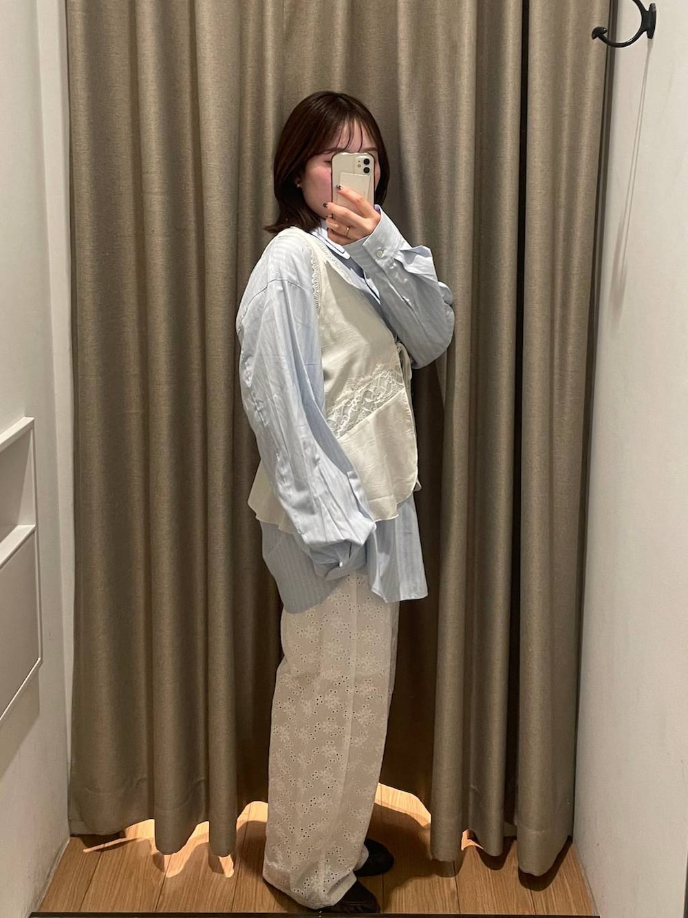 ブラック系のローファー、ホワイト系のベスト、ブルー系のシャツ/ブラウスを着用したレディースの春コーディネートの2枚目の写真