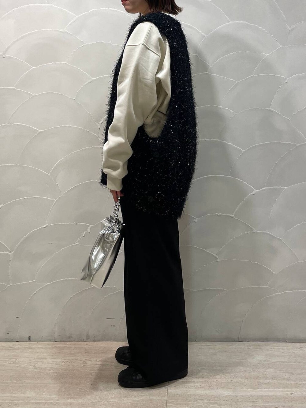 ホワイト系のスウェット、ブラック系のその他パンツ、シルバー系のショルダーバッグを着用したレディースの冬コーディネートの2枚目の写真