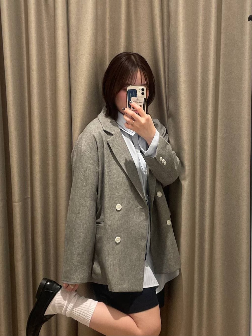 グレー系のテーラードジャケット、ブラック系のローファー、ブルー系のシャツ/ブラウスを着用したレディースの春コーディネートの2枚目の写真