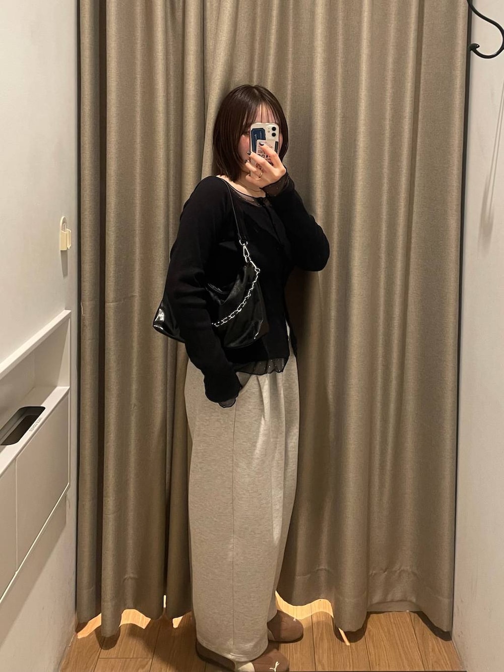 グレー系のスウェットパンツ、ブラック系のショルダーバッグ、ブラック系のTシャツ/カットソーを着用したレディースの冬コーディネートの2枚目の写真