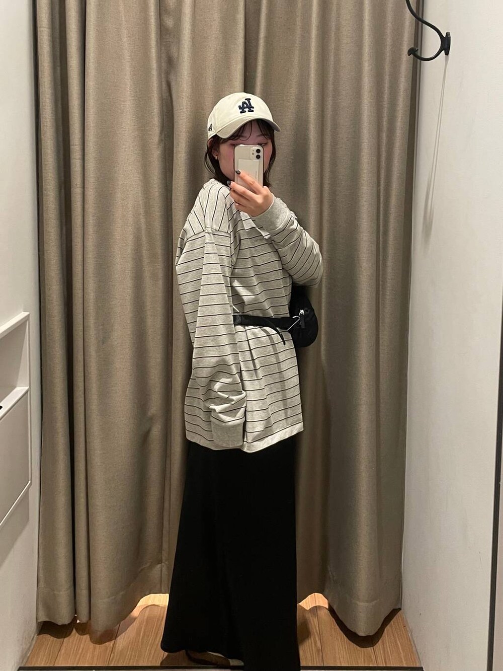 ブラック系のスカート、ブラック系のボディバッグ/ウエストポーチ、グレー系のTシャツ/カットソーを着用したレディースの春コーディネートの3枚目の写真