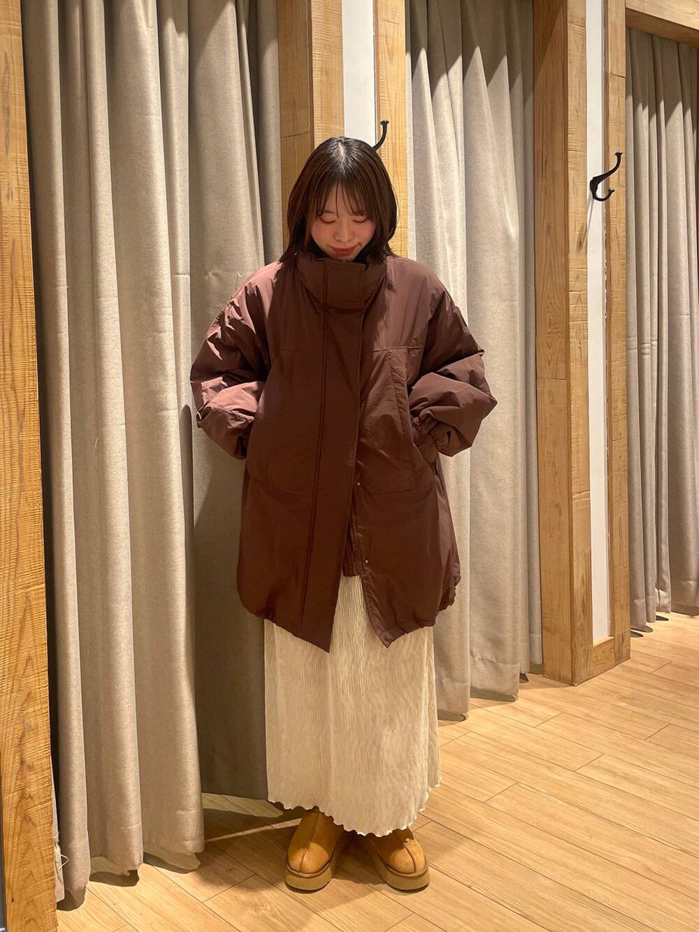 ブラウン系のブルゾン、ホワイト系のスカート、ブラウン系のその他シューズを着用したレディースの秋コーディネートの2枚目の写真