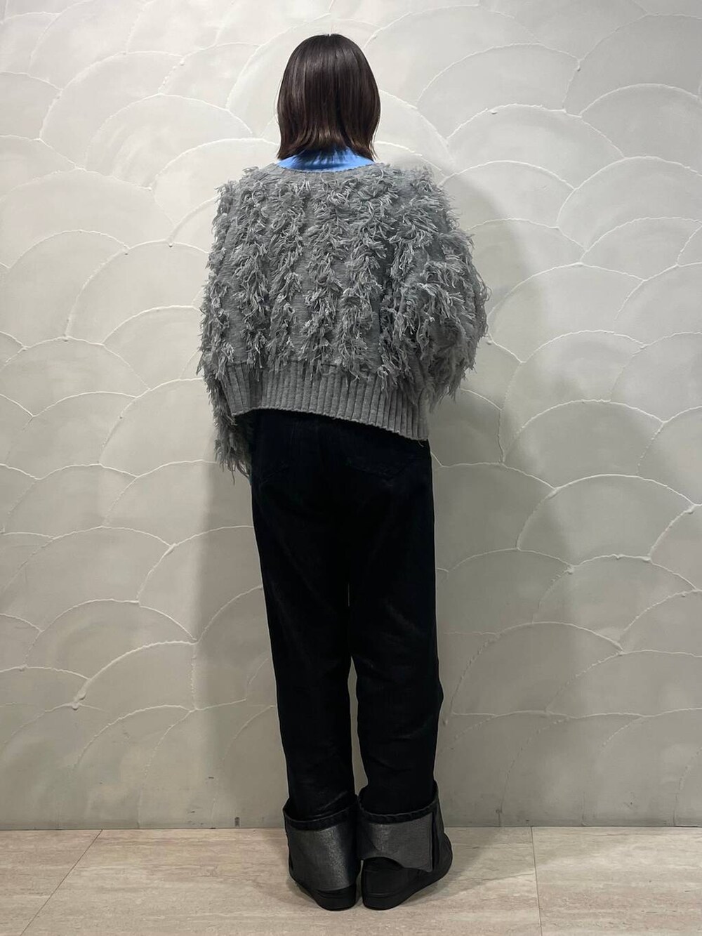 グレー系のカーディガン/ボレロ、ブルー系のTシャツ/カットソー、ブラック系のデニムパンツを着用したレディースの冬コーディネートの3枚目の写真