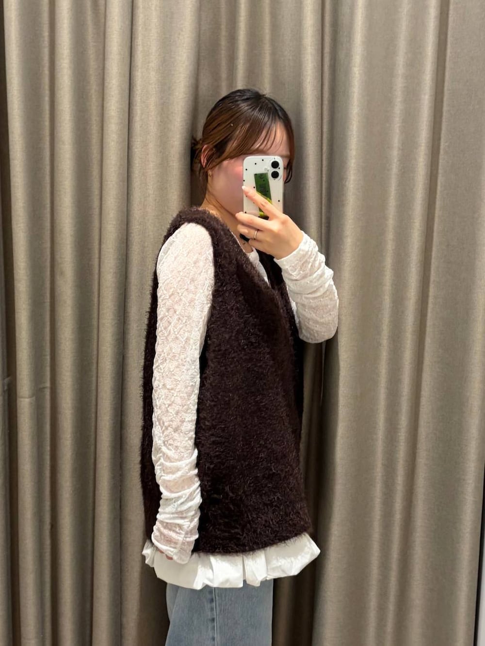 ブラック系のブーツ、ホワイト系のTシャツ/カットソー、ブラウン系のベストを着用したレディースの秋コーディネートの3枚目の写真