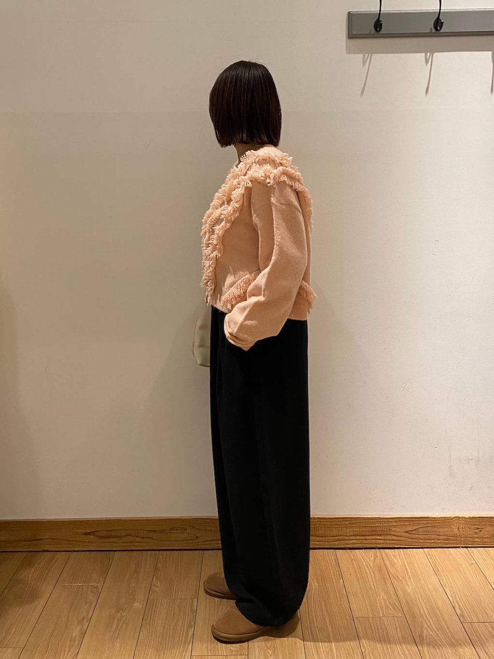 ホワイト系のショルダーバッグ、ブラック系のその他パンツ、ベージュ系のニット/セーターを着用したレディースの冬コーディネートの2枚目の写真