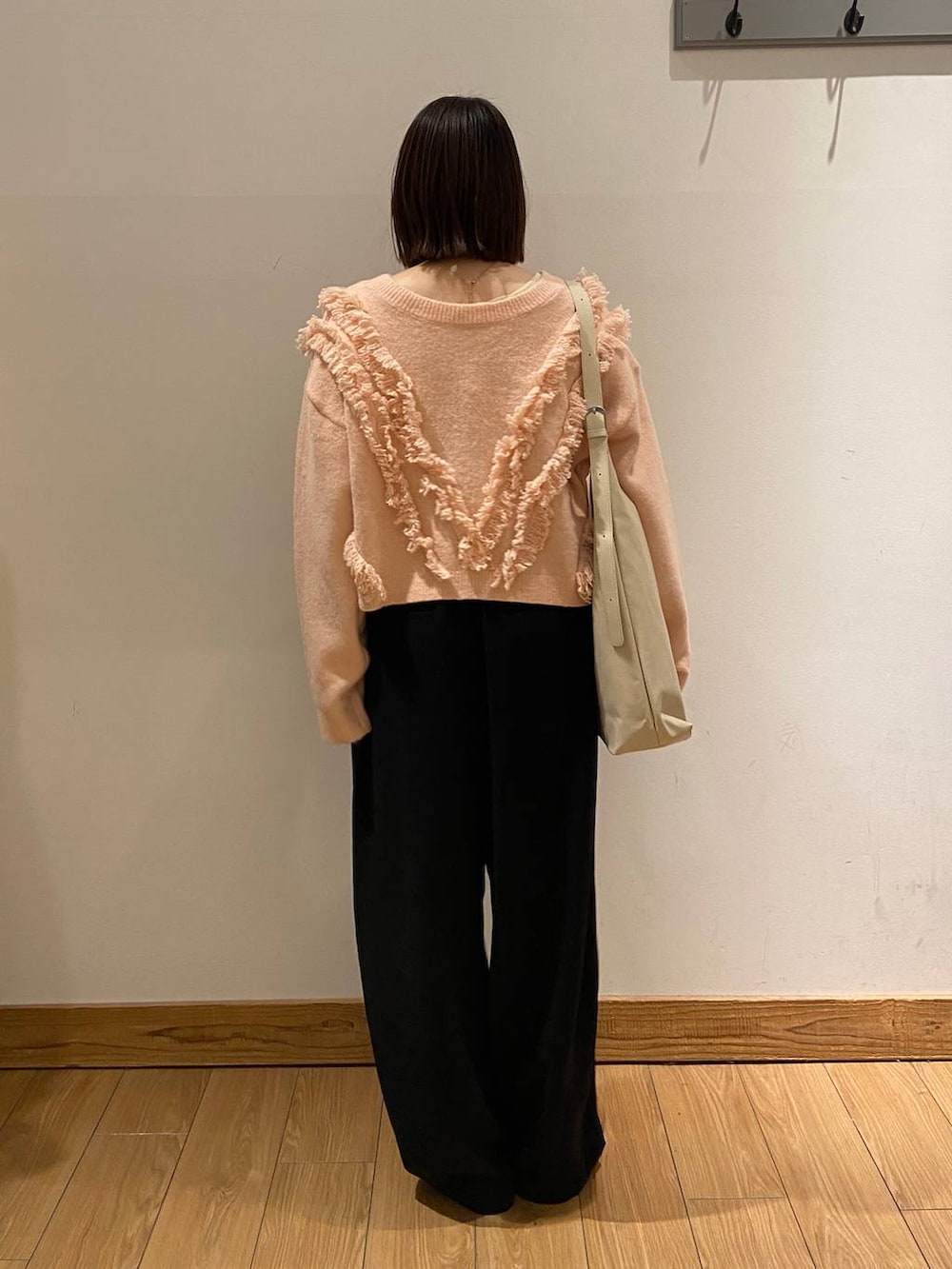 ホワイト系のショルダーバッグ、ブラック系のその他パンツ、ベージュ系のニット/セーターを着用したレディースの冬コーディネートの3枚目の写真