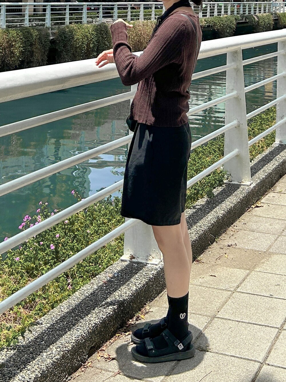 ブラック系のショルダーバッグ、ブラック系のサンダルを着用したレディースの夏コーディネートの2枚目の写真