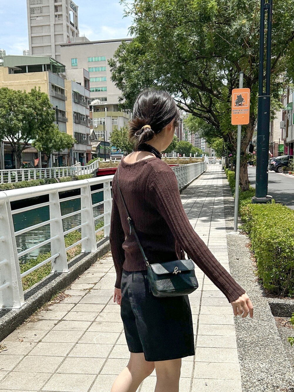 ブラック系のショルダーバッグ、ブラック系のサンダルを着用したレディースの夏コーディネートの3枚目の写真