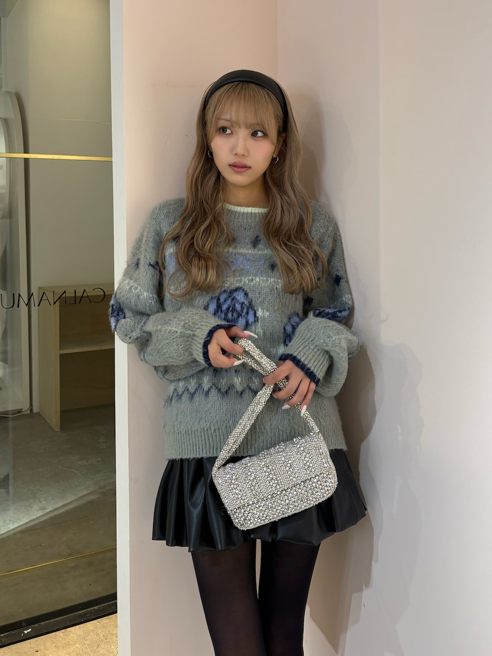 ブラック系のスカート、グレー系のニット/セーターを着用したレディースの秋コーディネートの5枚目の写真