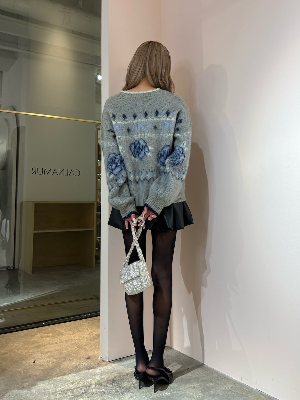 ブラック系のスカート、グレー系のニット/セーターを着用したレディースの秋コーディネートの4枚目の写真