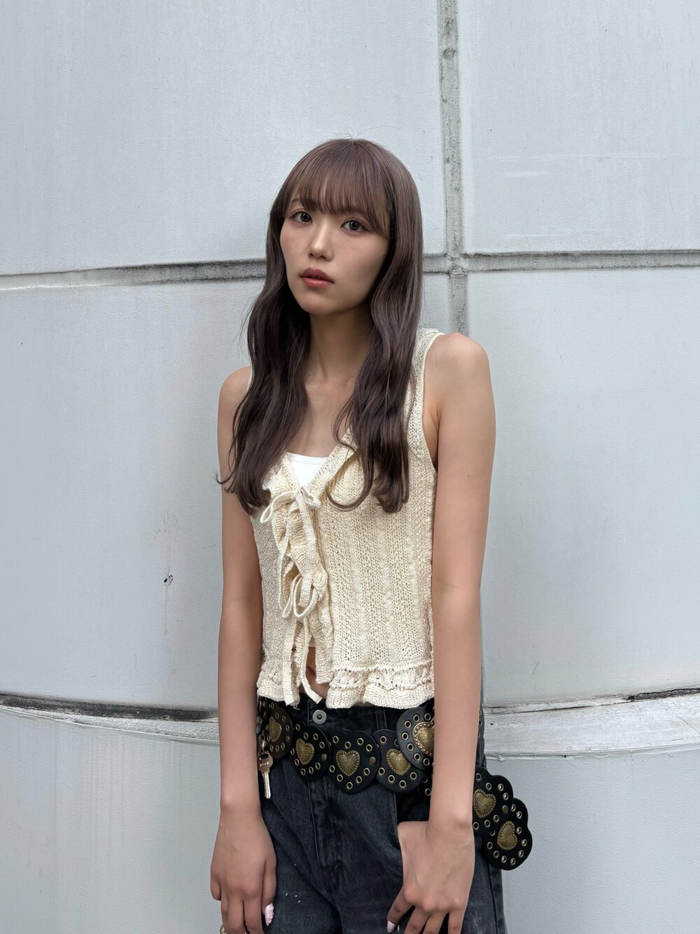 ホワイト系のニット/セーター、ブラック系のデニムパンツ、ブラック系のブーツを着用したレディースの春コーディネートの4枚目の写真