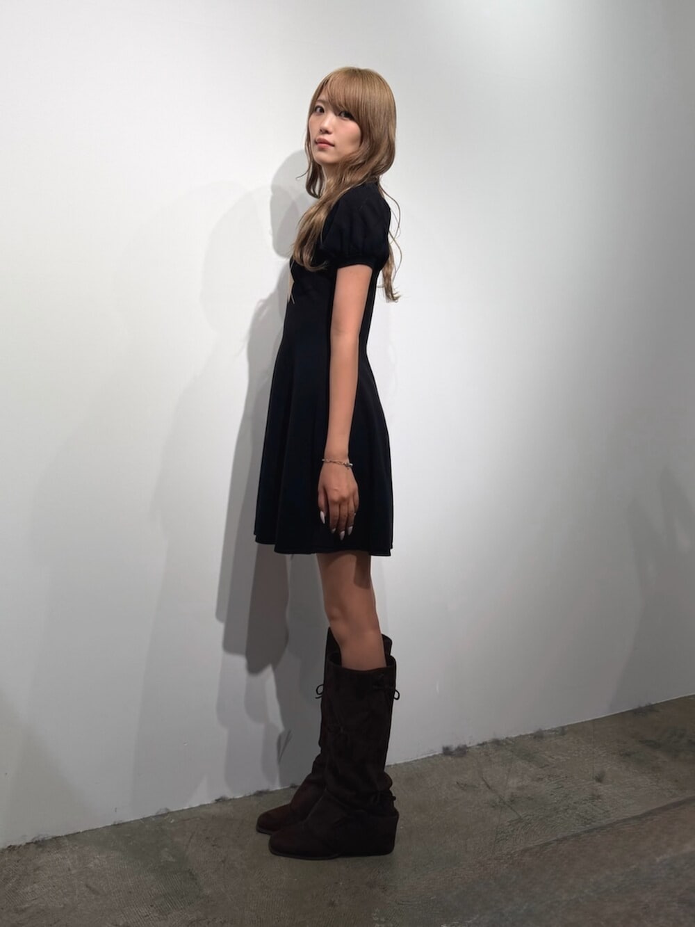ブラウン系のブーツ、ブラック系のワンピースを着用したレディースの夏コーディネートの2枚目の写真