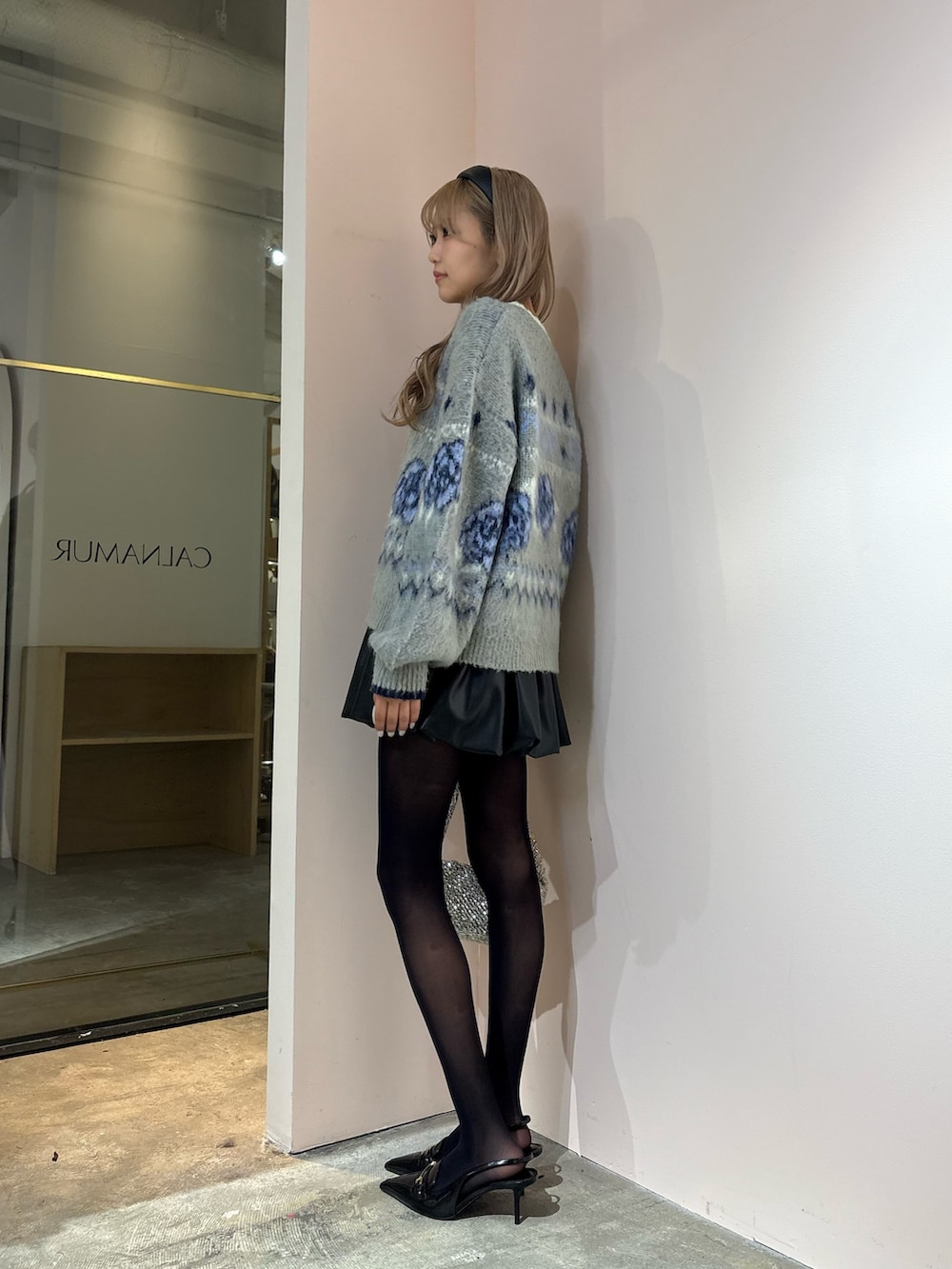 ブラック系のスカート、グレー系のニット/セーターを着用したレディースの秋コーディネートの3枚目の写真