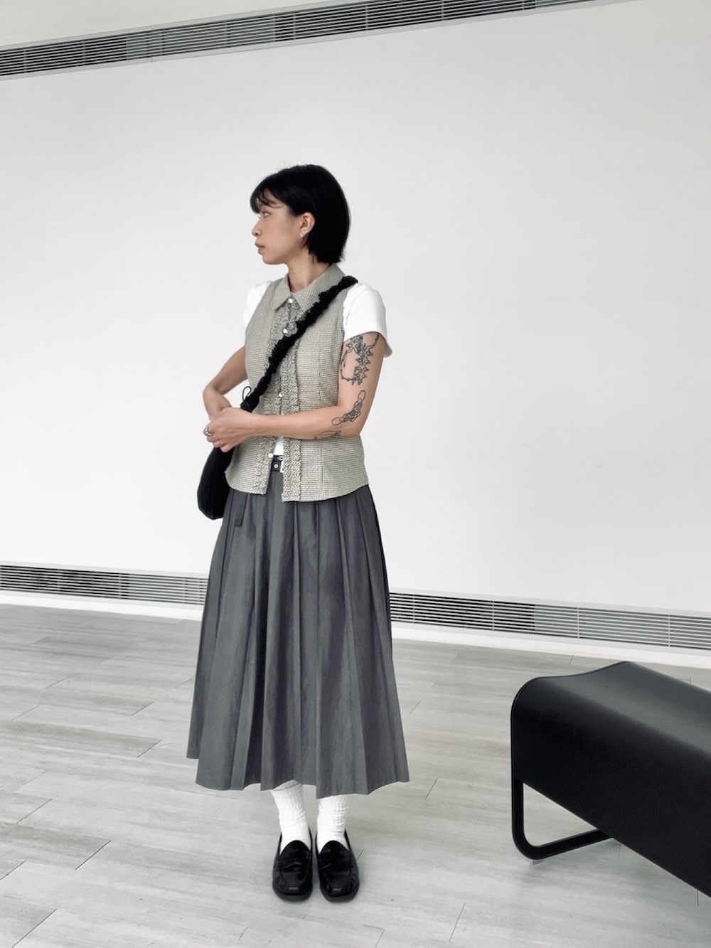 ブラック系のローファー、グレー系のスカート、グリーン系のシャツ/ブラウスを着用したレディースの夏コーディネートの2枚目の写真