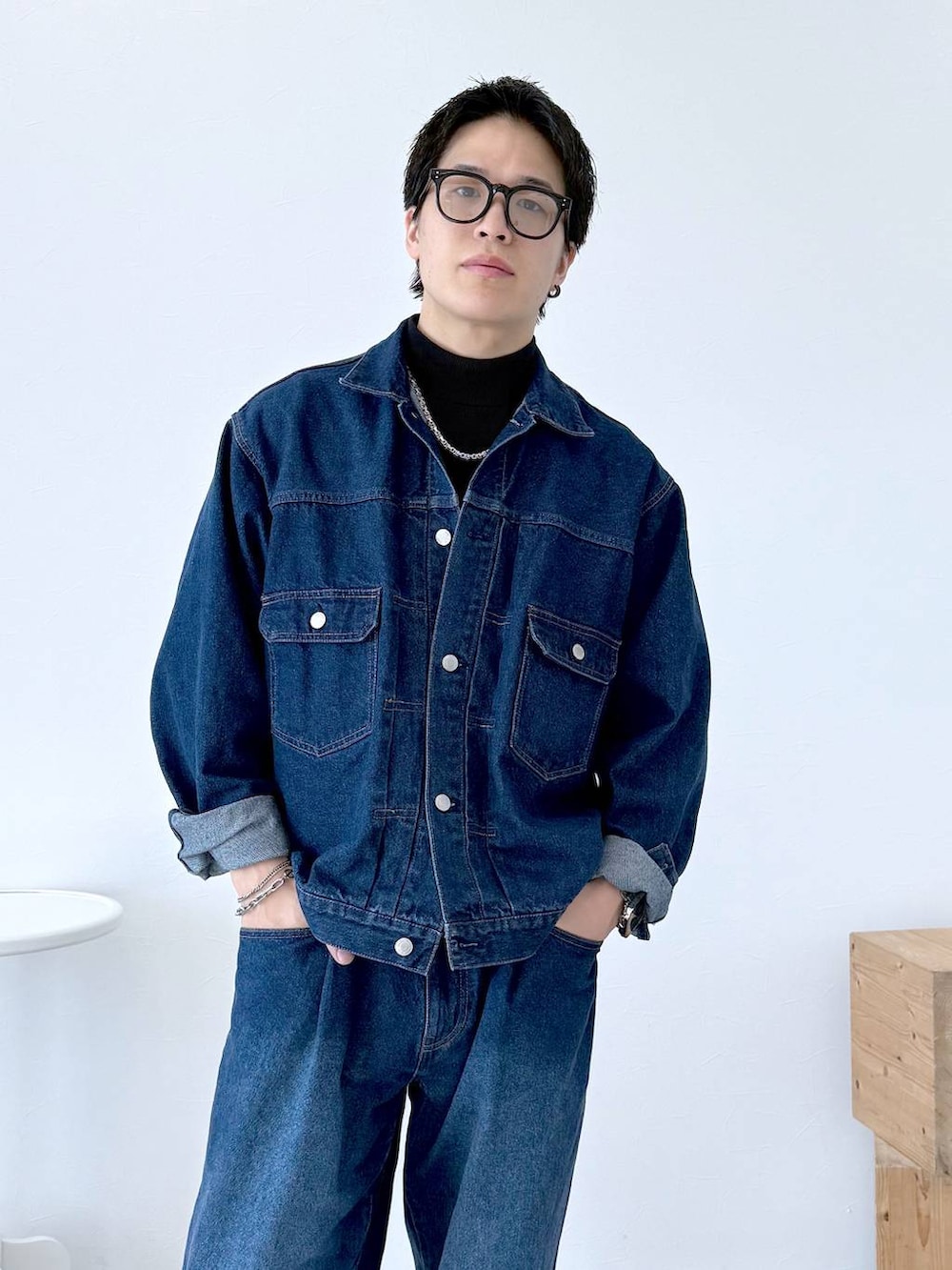 ブラック系のニット/セーター、ブルー系のデニムジャケット、ブルー系のデニムパンツを着用したメンズの秋コーディネートの6枚目の写真