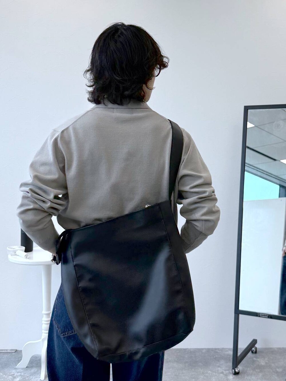 ブルー系のデニムパンツ、ベージュ系のニット/セーター、ブラック系のその他シューズを着用したメンズの秋コーディネートの7枚目の写真
