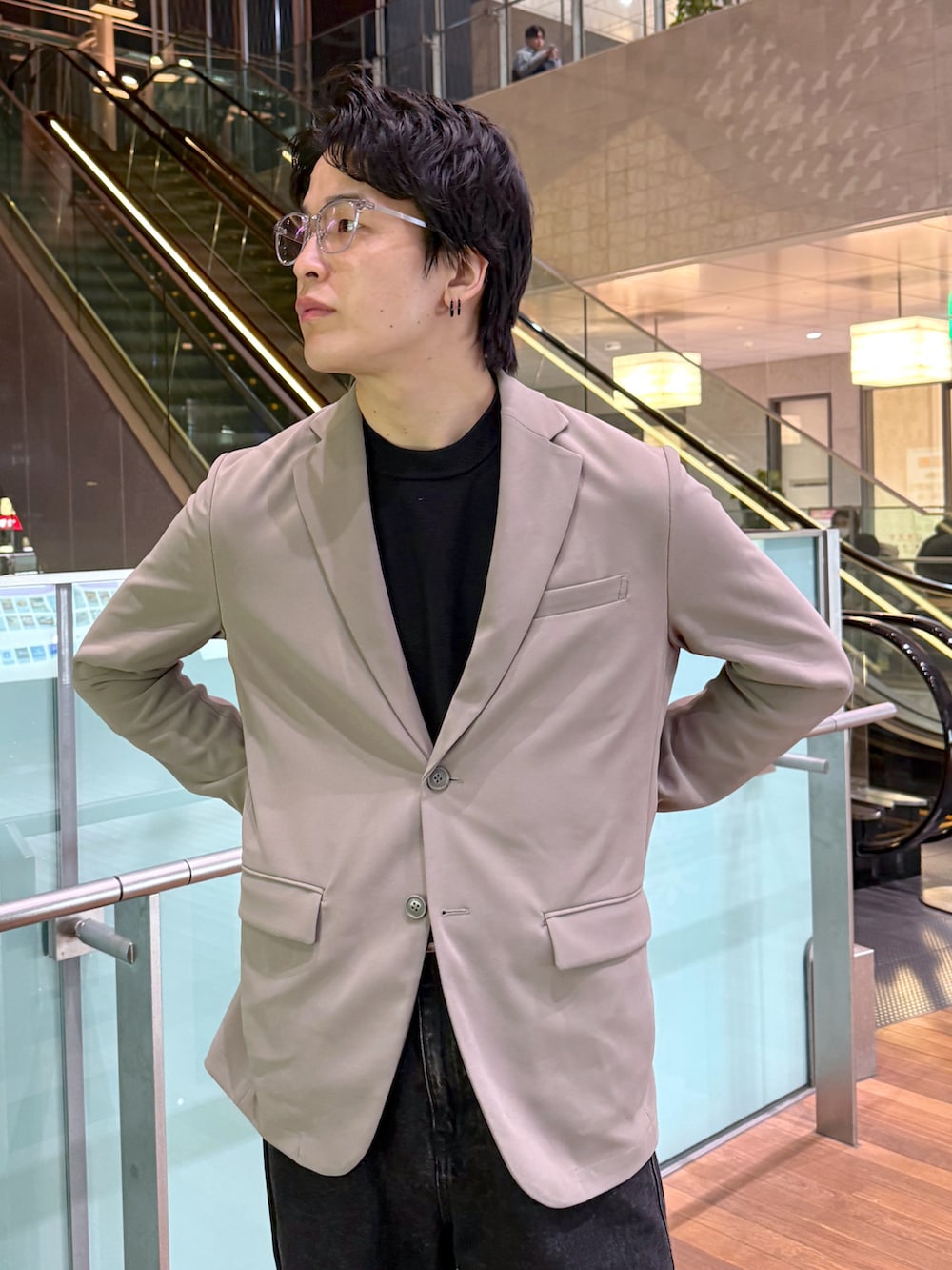 ブラック系のデニムパンツ、ブラック系のニット/セーター、ベージュ系のテーラードジャケットを着用したメンズの冬コーディネートの5枚目の写真