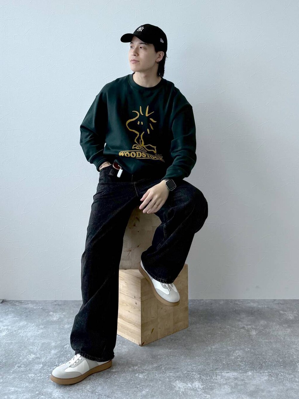 ベージュ系のスニーカー、ブラック系のデニムパンツ、ブラック系のキャップを着用したメンズの秋コーディネートの2枚目の写真