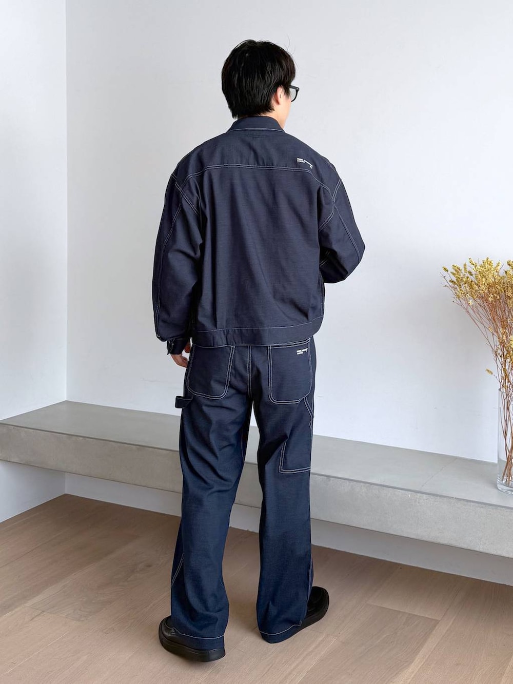 ブルー系のTシャツ/カットソー、グレー系のその他シューズ、ブルー系のデニムパンツを着用したメンズの秋コーディネートの4枚目の写真